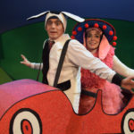 Al Kroeten and Miriam Gutierrez in Go Dog Go, dressed in dog costumes inside a tiny red cartoon car