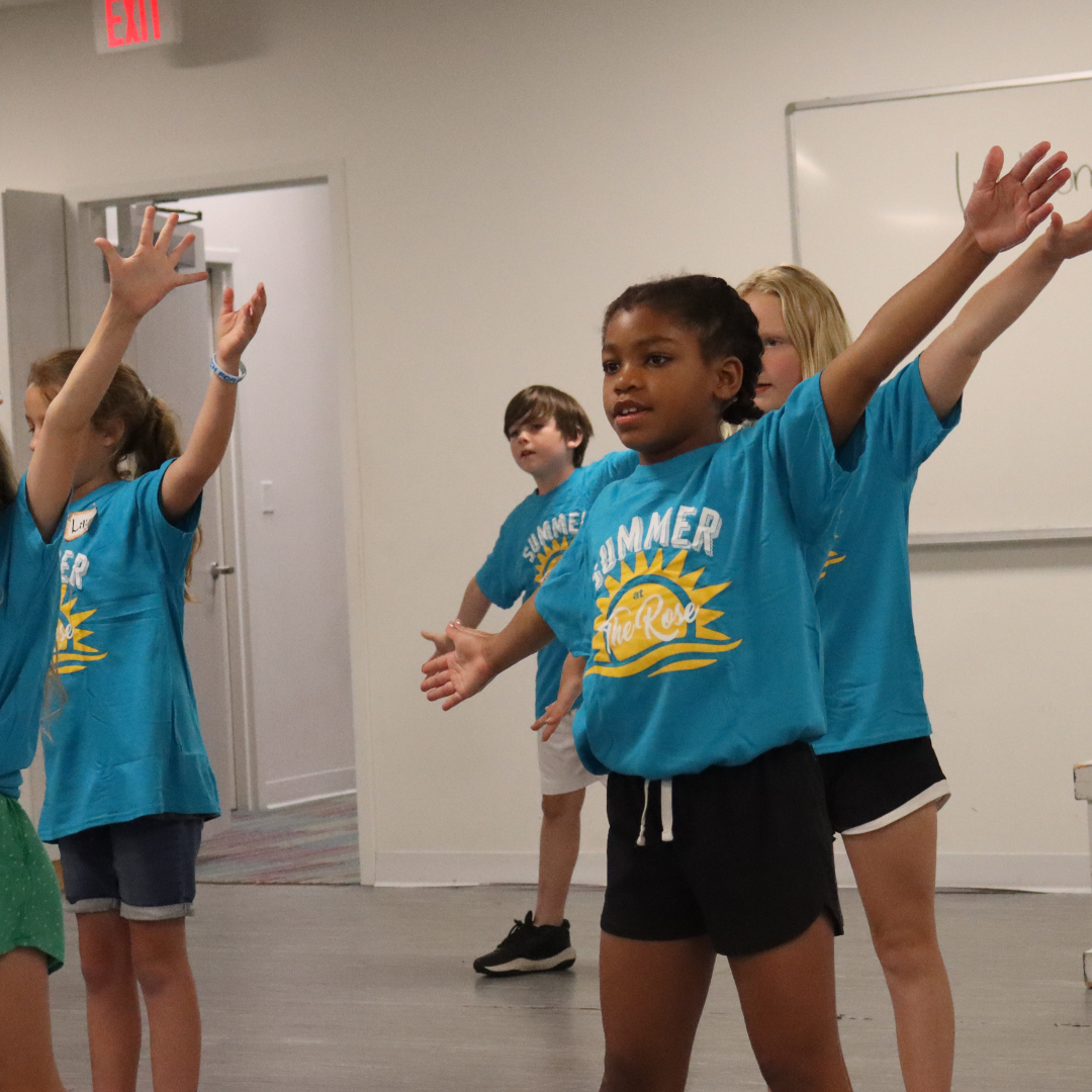 Young Summer campers warming up to perform wearing matching Summer shirts.