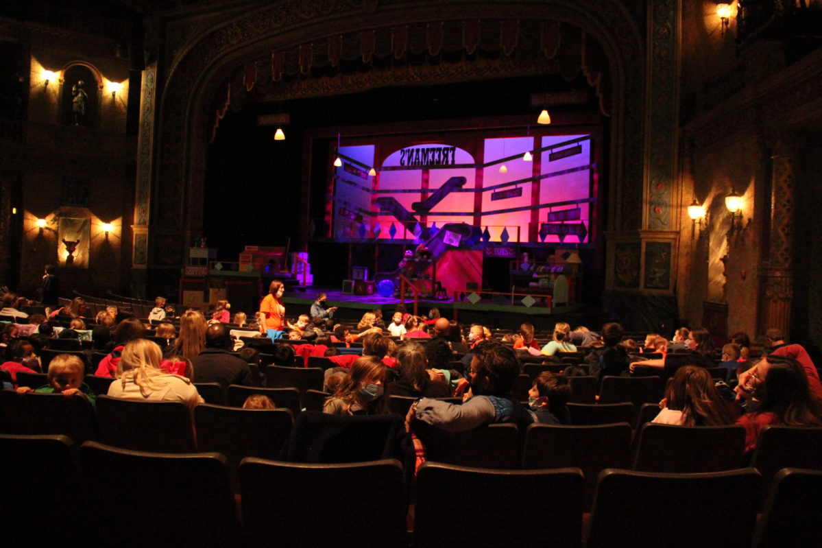 A full audience seated in the theater waiting for their performance to begin.